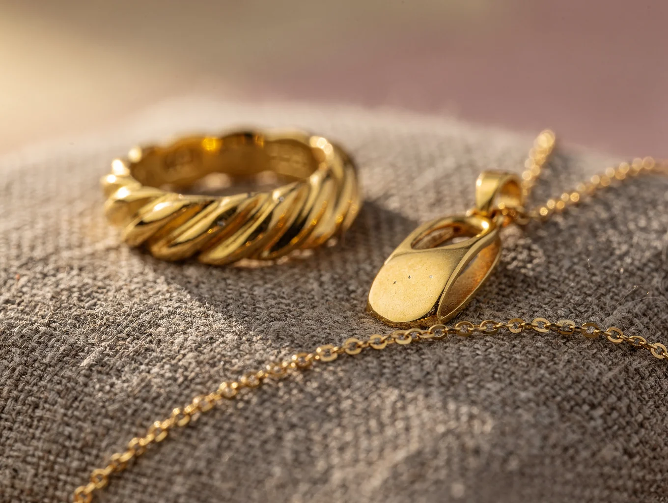 Hand-forged gold jewelry capsule featuring textured rings and pendants
